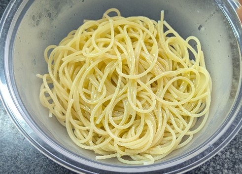 2.	ボウルに茹でたパスタをいれ、オリーブオイルを全体に絡めます。